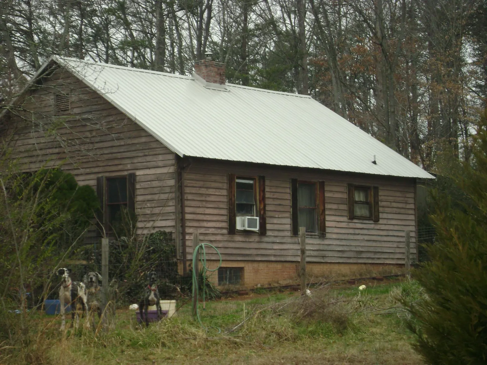 White metal roof on an old wood sided farmhouse, from a Metal Roof Installation job in Wilson